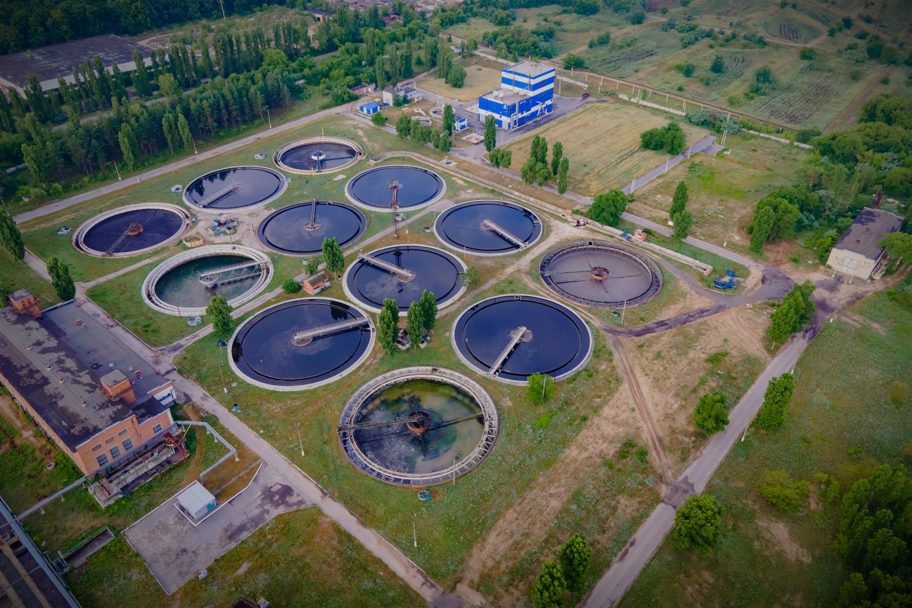 Vista aérea de uma estação de tratamento de efluentes cercada de área verde